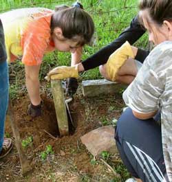 Loudoun Valley High School students Elisabeth Harris (right) and Justine McDonald reset a leaning gravestone.